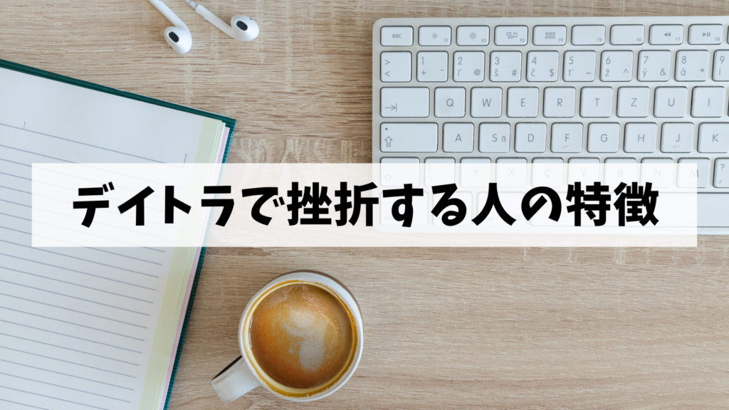 木のテーブルにキーボード、コーヒー、ノート、イヤホンが置かれています