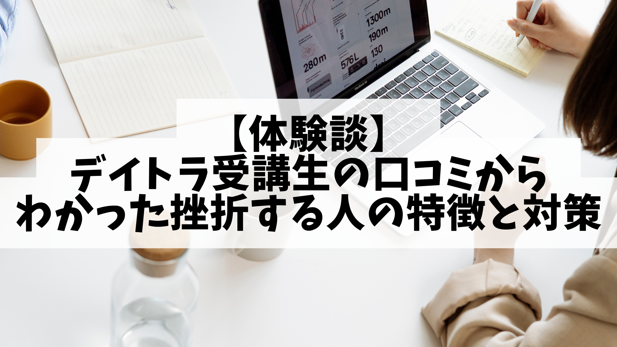 女性が白いデスクの上でパソコン作業をしています